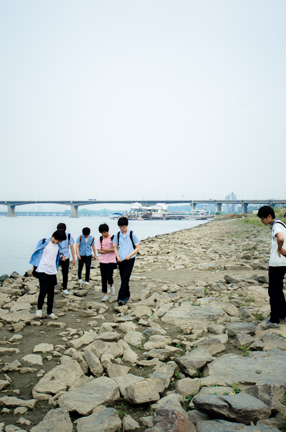 川辺を歩く学生