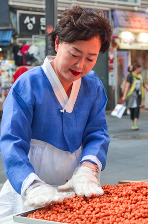 伝統菓子(カンジョン)を作る店員